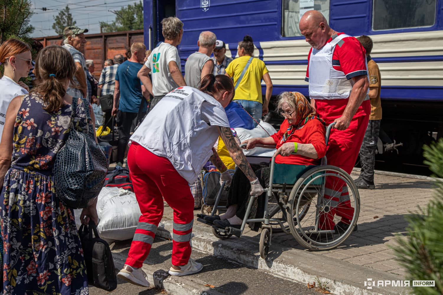 Volunteers help an elderly woman in a wheelchair board an evacuation train in Pokrovsk in August 2024